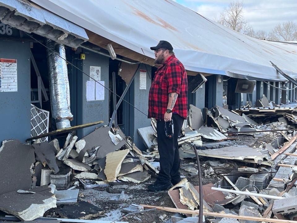 Tanner Watkins, a game technician at Big Play in Hendersonville, looks through sections of the building reduced to rubble.