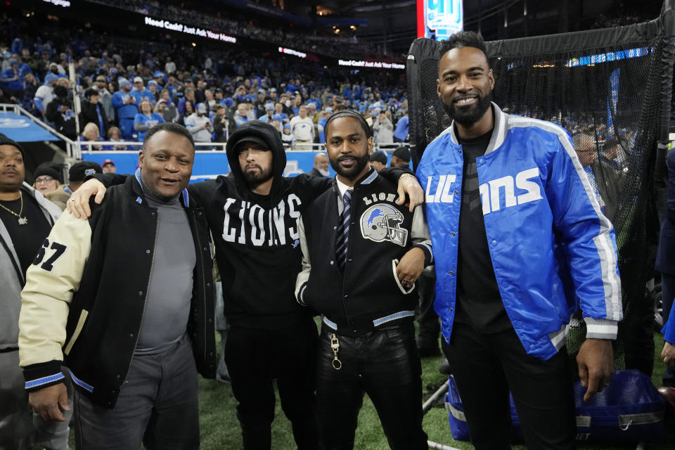 From left, former Detroit Lions running back Barry Sanders stands with musicians Eminem and Big Sean and former receiver Calvin Johnson during pregame of an NFL wild-card playoff football game against the Los Angeles Rams, Sunday, Jan. 14, 2024, in Detroit. (AP Photo/Paul Sancya)
