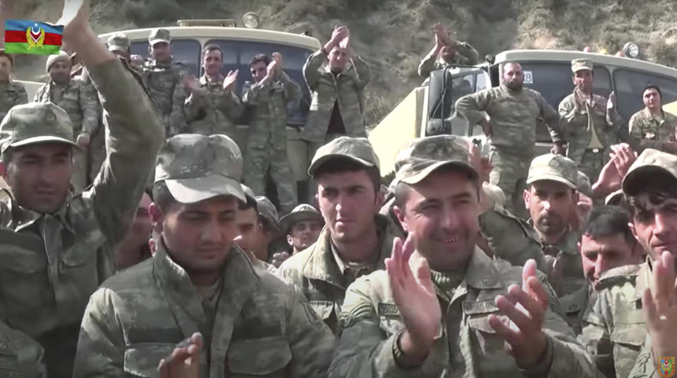 In this grab taken from video released by Azerbaijan's Defense Ministry on Saturday, Oct. 3, 2020, Azerbaijan's solders applaud at a meeting with officers during fighting with forces of the self-proclaimed Republic of Nagorno-Karabakh, Azerbaijan. Armenia and Azerbaijan on Saturday said heavy fighting is continuing in their conflict over the separatist territory of Nagorno-Karabakh. Azerbaijan's president criticized the international mediators who have tried for decades to resolve the dispute. (Azerbaijan's Defense Ministry via AP)