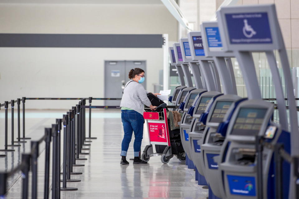 A person wearing a protective mask walks through terminal 1 at Toronto's Pearson Airport after mandatory coronavirus disease (COVID-19) testing took effect for international arrivals in Mississauga, Ontario, Canada February 15, 2021.  REUTERS/Carlos Osorio