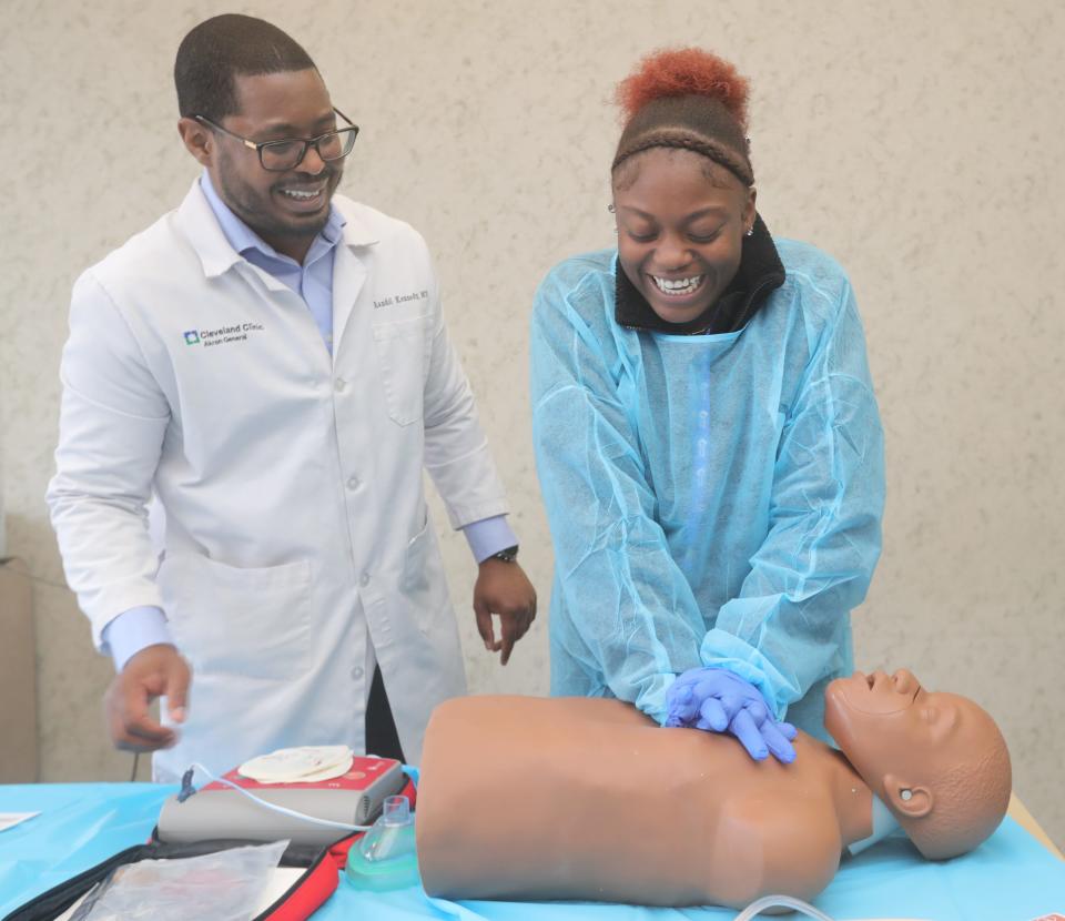 Cleveland Clinic Akron General Dr. Randol Kennedy helps Buchtel High School student Tracy Summers learn CPR during a Black Men in White Coats Summit on Thursday, Oct. 27, 2022 in Akron, Ohio, at the University of Akron.