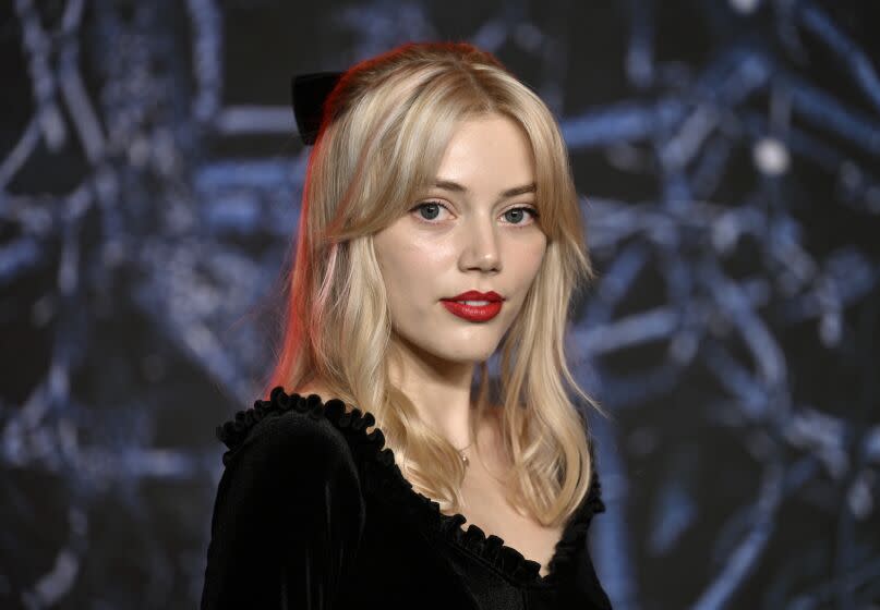 A young woman with blond hair in a black dress