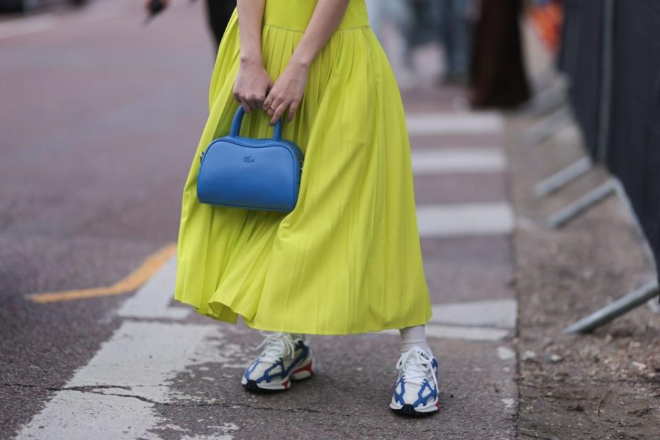 paris, france march 05 a guest is seen wearing a lime neon yellow dress, light blue leather bag, white socks and lacoste white and blue sneakers seen wearing outside lacoste show during the womenswear fallwinter 20242025 as part of paris fashion week on march 05, 2024 in paris, france photo by jeremy moellergetty images