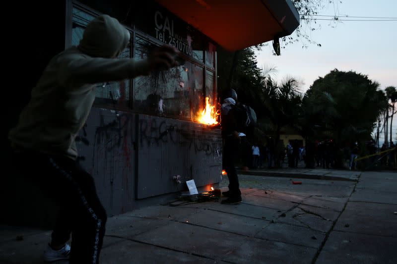 People vandalize the exterior of a police station during a protest after a man, who was detained for violating social distancing rules, died from being repeatedly shocked with a stun gun by officers, according to authorities, in Bogota