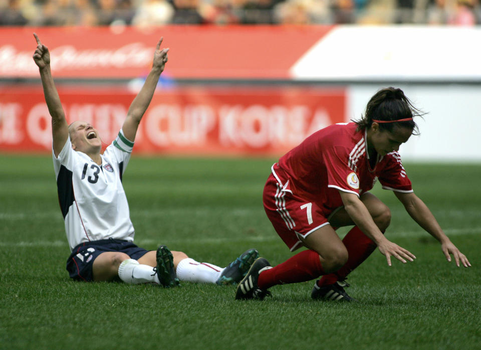 SEOUL, REPUBLIC OF KOREA:  Kristine Marie Lilly (L) of the US celebrates after scoring a goal as Canada's Isabelle Morneau (R) falls down during Peace Queen Cup football final in Seoul, 04 November 2006. The US defeated Canada 1-0. AFP PHOTO/CHOI WON-SUK  (Photo credit should read CHOI WON-SUK/AFP via Getty Images)