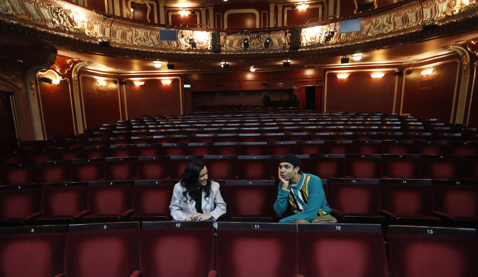 Leading actors of the musical "Everybody's Talking About Jamie', Noah Thomas, right who plays Jamie and Hiba Elichike, who portrays Pritti Pasha, speak to the Associated Press in the auditorium of the Apollo Theater where the musical is preparing to continue its run in London, Tuesday, April 20, 2021. (AP Photo/Alastair Grant)