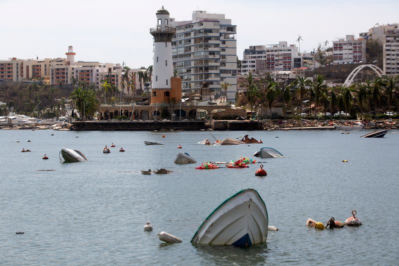 Barcos hundidos se ven cerca de un faro tras el paso del huracán Otis, en Acapulco, México