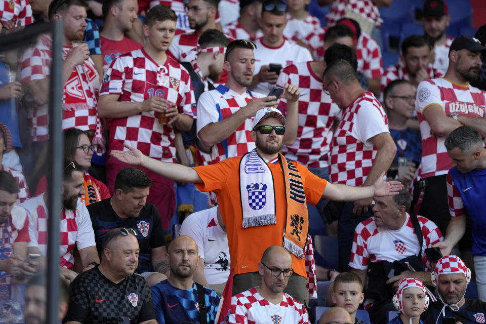 A fan wearing the Netherlands orange stands among Croatia supporters while waiting for the start of the Nations League semifinal soccer match between the Netherlands and Croatia at De Kuip stadium in Rotterdam, Netherlands, Wednesday, June 14, 2023. (AP Photo/Peter Dejong)