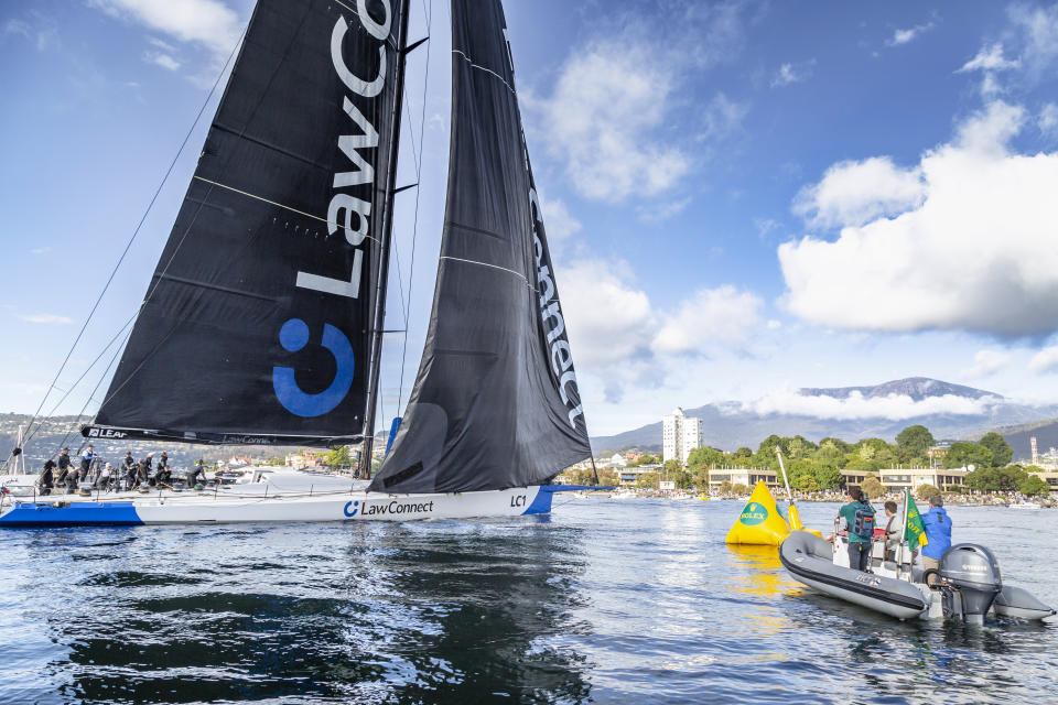 In this photo provided by Rolex/Cruising Yacht Club of Australia,, uper maxi LawConnect crosses the finish line of the Sydney Hobart yacht race in Hobart, Australia, Thursday, Dec. 28, 2023. LawConnect wins the battle to finish to take line honors in the 628-nautical mile race. (Kurt Arrigo/Rolex/CYCA via AP)