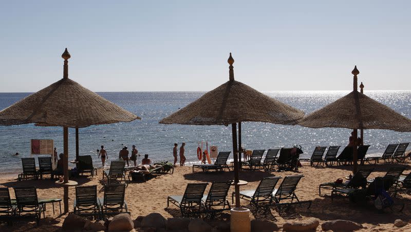 Tourists stand in shallow waters at a closed beach in the Red Sea resort of Sharm el-Sheik, Egypt Tuesday, Dec. 7, 2010. A Russian citizen was killed by a tiger shark attacking him a few feet away from popular Egyptian resort in Hurghada.