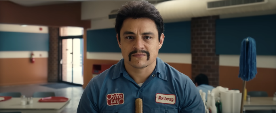 A man in a "Frito Lay" uniform sweeps the floor