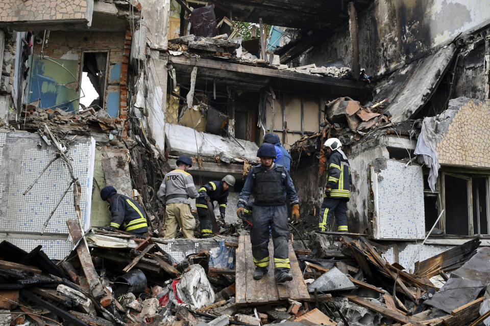 Rescuers work at a site of an apartment building destroyed by Russian shelling in Bakhmut, Donetsk region, Ukraine, Wednesday, May 18, 2022. (AP Photo/Andriy Andriyenko)