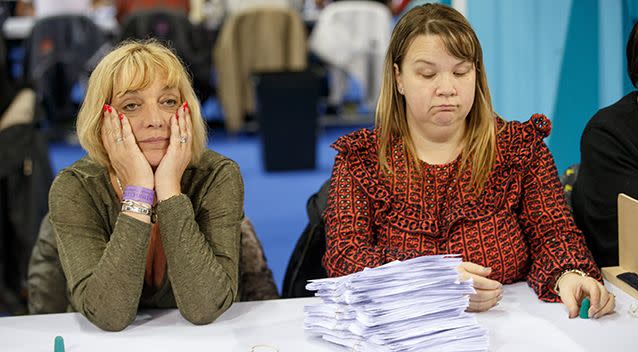 Election officials react during vote counting in the Emirates Arena in Glasgow, Scotland. Picture: AAP