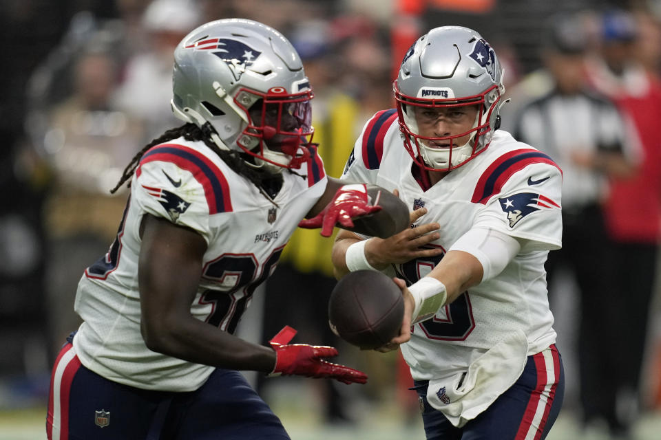 New England Patriots quarterback Mac Jones (10) hands off the ball to running back Rhamondre Stevenson (38) during the first half of an NFL preseason football game against the Las Vegas Raiders, Friday, Aug. 26, 2022, in Las Vegas. (AP Photo/John Locher)