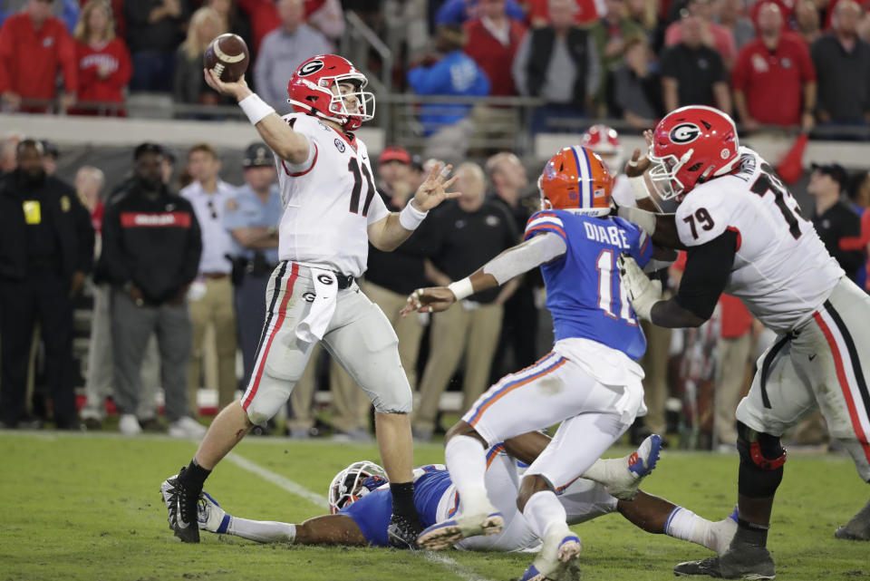 Georgia quarterback Jake Fromm (11) throws a pass during the second half as Florida linebacker Mohamoud Diabate, center, rushes on Saturday in Jacksonville, Fla. (AP Photo/John Raoux)