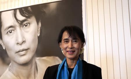 Myanmar opposition leader Aung San Suu Kyi poses with a picture of herself at the Nobel Peace centre in Oslo June 16, 2012. REUTERS/Cathal McNaughton/Files