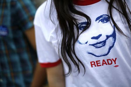 A supporter of former U.S. Secretary of State Hillary Clinton wears a T-shirt with an image depicting her as people arrive to hear her speak about her new book "Hard Choices" at the George Washington University in Washington June 13, 2014. REUTERS/Jonathan Ernst/File Photo