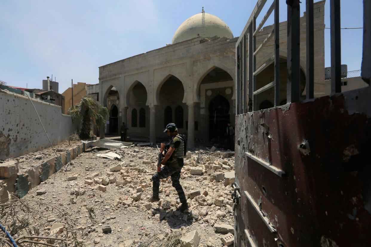 A member of Iraqi Federal Police walks through the rubble outside a mosque in Mosul's Old City: Reuters