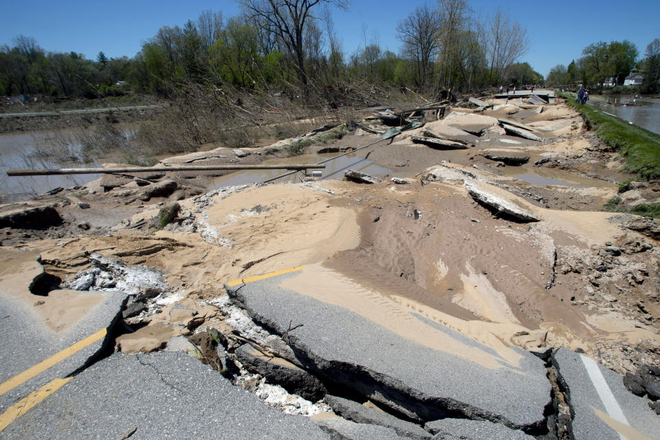 Chunks of asphalt rest broken apart after flood waters decimated the bridge in downtown Sanford, Mich., on Thursday, May 21, 2020. After dam failures upstream this week, water flooded the village, destroying homes and businesses, uprooting trees and crumbling bridges and infrastructure. (Jake May/MLive.com/The Flint Journal via AP)