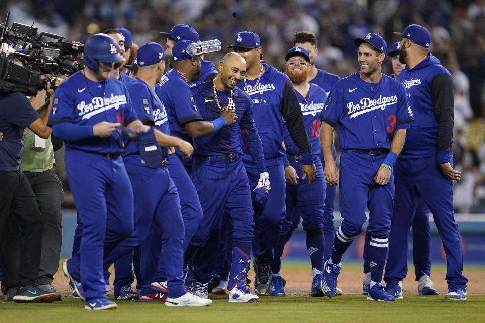 Los Angeles Dodgers' Mookie Betts, center, is greeted by teammates after he hit a walk-off single to win a baseball game 3-2 against the Arizona Diamondbacks in Los Angeles, Thursday, Sept. 22, 2022. Freddie Freeman scored. (AP Photo/Ashley Landis)