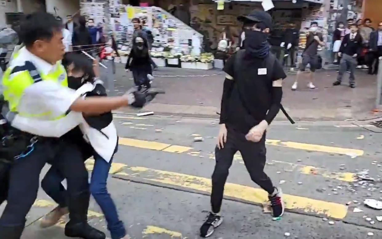 A Hong Kong police officer shot at masked protesters on Monday - AFP