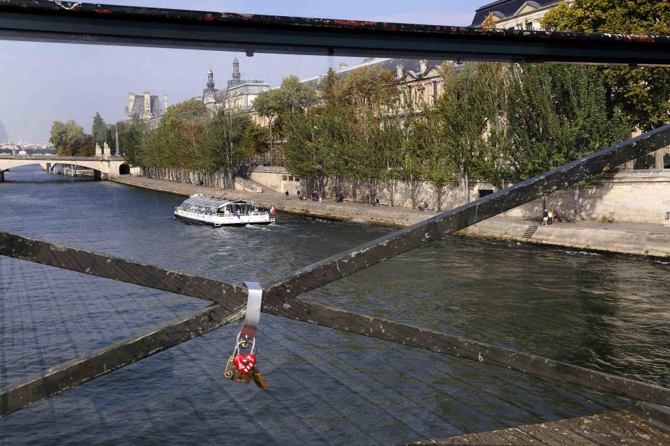 Padlocks are seen through a plastic panel which protects the fence of the Pont des Arts over the River Seine in Paris September 23, 2014. (REUTERS/Jacky Naegelen)