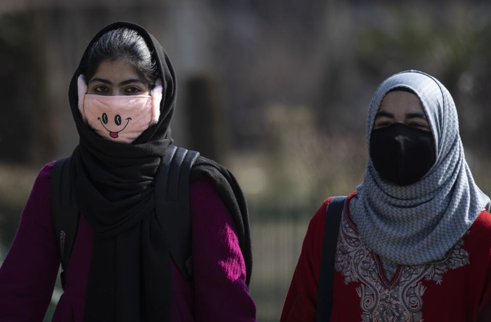 Kashmiri students wearing face masks arrive as colleges reopened eleven months after being closed due to the coronavirus pandemic in Srinagar, Indian controlled Kashmir, Monday, Feb. 15, 2021. (AP Photo/Mukhtar Khan)