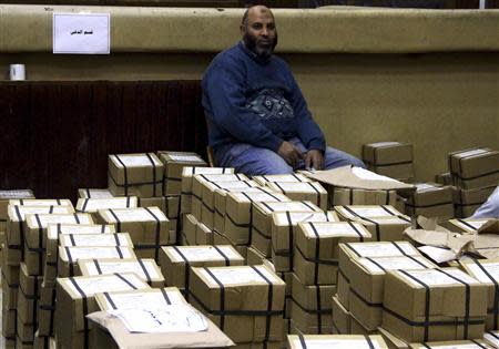 An Egyptian man sits among boxes containing voting slips for a referendum on the new constitution in Cairo January 12, 2014. REUTERS/Al Youm Al Saabi Newspaper