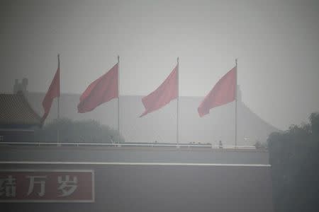 FILE PHOTO: Red flags flutter on Tiananmen Gate during a heavily hazy day in Beijing October 24, 2014. REUTERS/Jason Lee