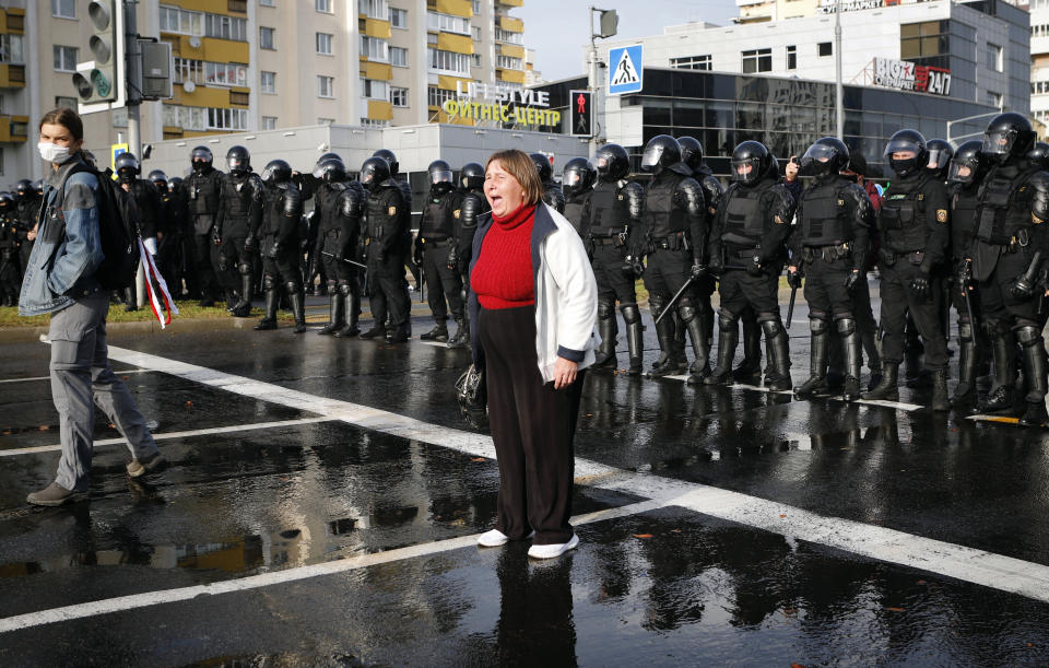 A protester shouts in front of a riot police line during a rally in Minsk, Belarus, Sunday, Oct. 4, 2020. Hundreds of thousands of Belarusians have been protesting daily since the Aug. 9 presidential election. (AP Photo)