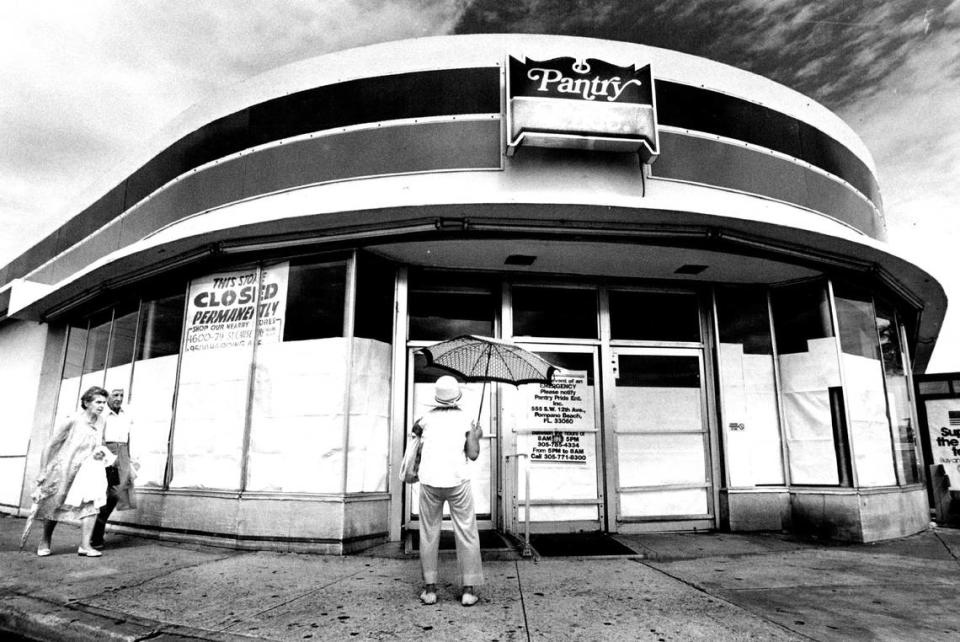 Former customers of Pantry Pride in Normandy Isles in Miami Beach check out signs on its closing.