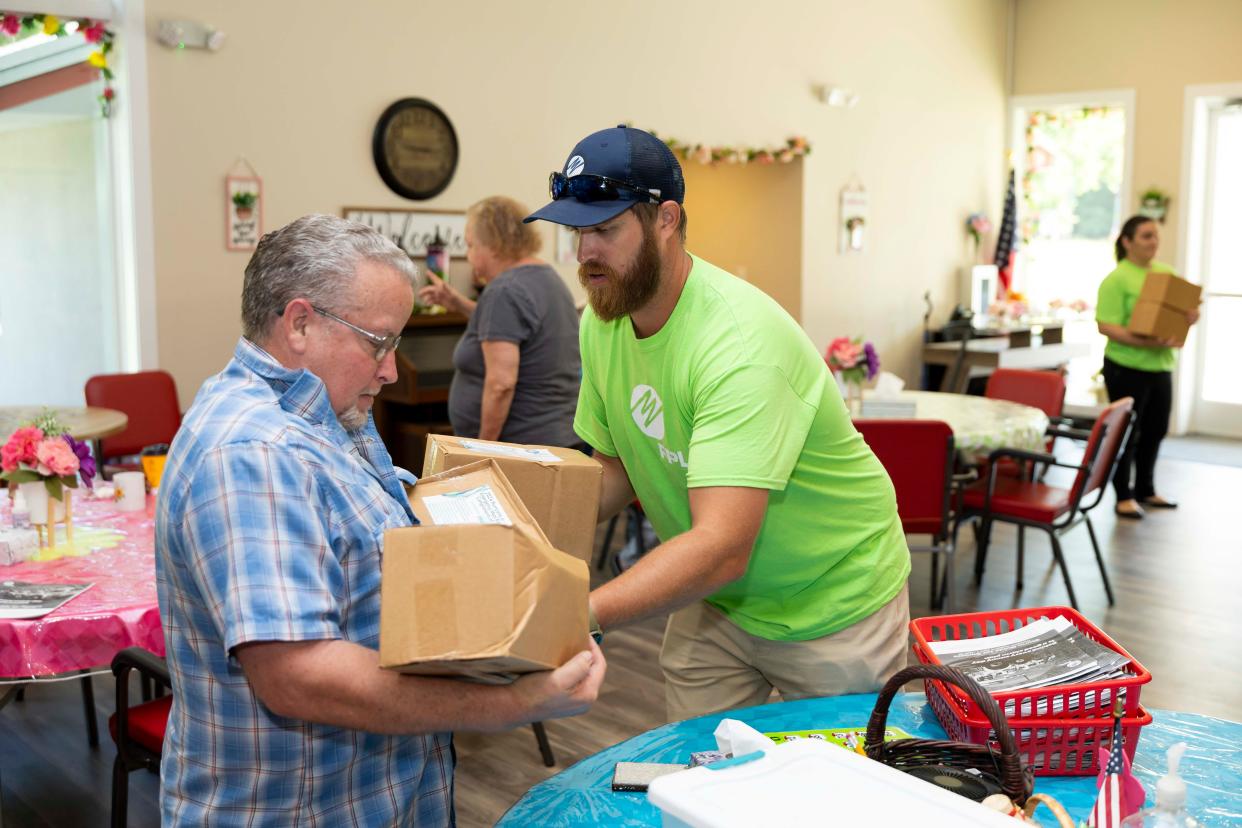 Samuel Mayfield, a Florida Power & Light community relations specialist, gives a hurricane preparedness meal kit to Nassau County senior James Betts. The utility and the Nassau County Council on Aging distributed 450 kits to 150 seniors.