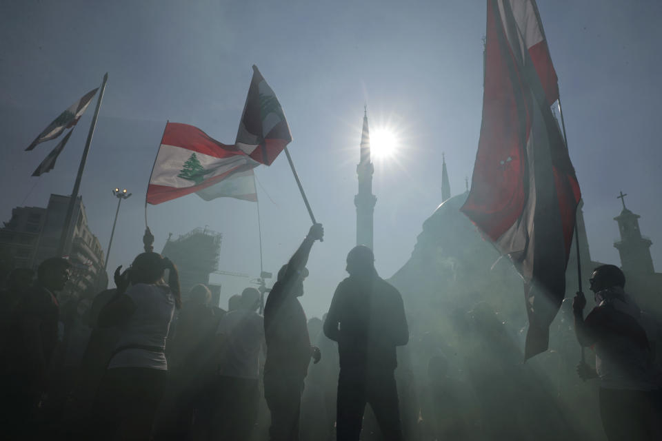 Anti-government protesters wave Lebanese national flags as gather during separate civil parade at the Martyr square, in downtown Beirut, Lebanon, Friday, Nov. 22, 2019. Protesters gathered for alternative independence celebrations, converging by early afternoon on Martyrs’ Square in central Beirut, which used to be the traditional location of the official parade. Protesters have occupied the area, closing it off to traffic since mid-October. (AP Photo/Hassan Ammar)