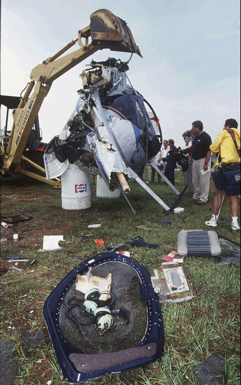 FILE - NTSB investigators and members of the news media look over the Hughes helicopter crash site in the infield of Talladega Superspeedway that killed NASCAR driver Davey Allison, July 13, 1993, in Talladega, Ala. Driver Red Farmer was also injured in the crash. NASCAR marks its 75th year in 2023, recalling both its highs and lows. (Hal Yeager/The Birmingham News, File)