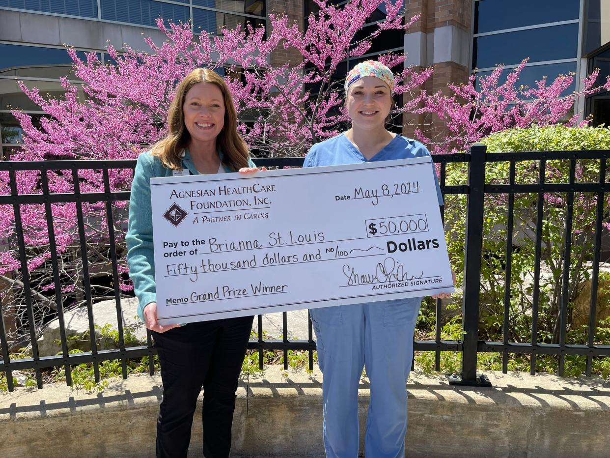 Shawn Fisher, left, Agnesian HealthCare Foundation executive director, presents the Samaritan Cash Raffle grand prize to Brianna St. Louis, a Fond du Lac resident.