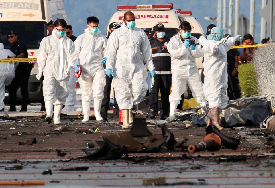 Authorities inspect the scene of a plane crash in Shah Alam, Malaysia (REUTERS)