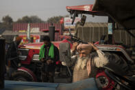 Sonu Singh, an elderly farmer, ties his turban while getting ready to join other farmers protesting against new farming laws they say will result in exploitation by corporations, eventually rendering them landless, at the Delhi-Haryana state border, India, Tuesday, Dec. 1, 2020. The busy, nonstop, arterial highways that connect most northern Indian towns to this city of 29 million people, now beat to the rhythm of never-heard-before cries of "Inquilab Zindabad" ("Long live the revolution"). Tens and thousands of farmers, with colorful distinctive turbans and long, flowing beards, have descended upon its borders where they commandeer wide swathes of roads. (AP Photo/Altaf Qadri)