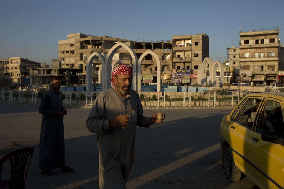 In this Thursday, Sept. 5, 2019, photo, a truck driver takes a tea break in al-Naim square, used by Islamic State militants for execution during their rule, in Raqqa, Syria. It is now renamed Freedom square. (AP Photo/Maya Alleruzzo)