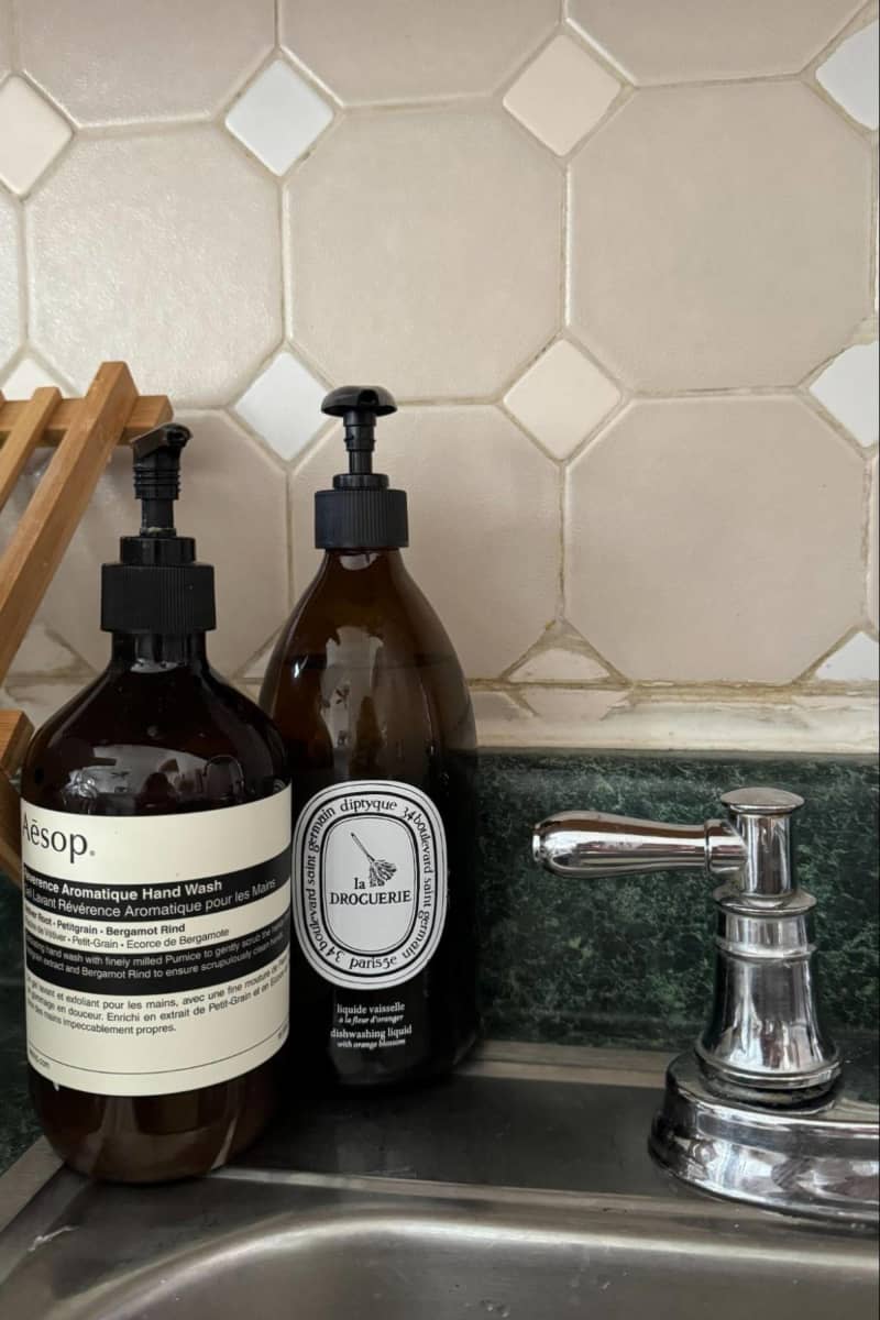 Diptyque and Aesops hand soap bottle next to sink