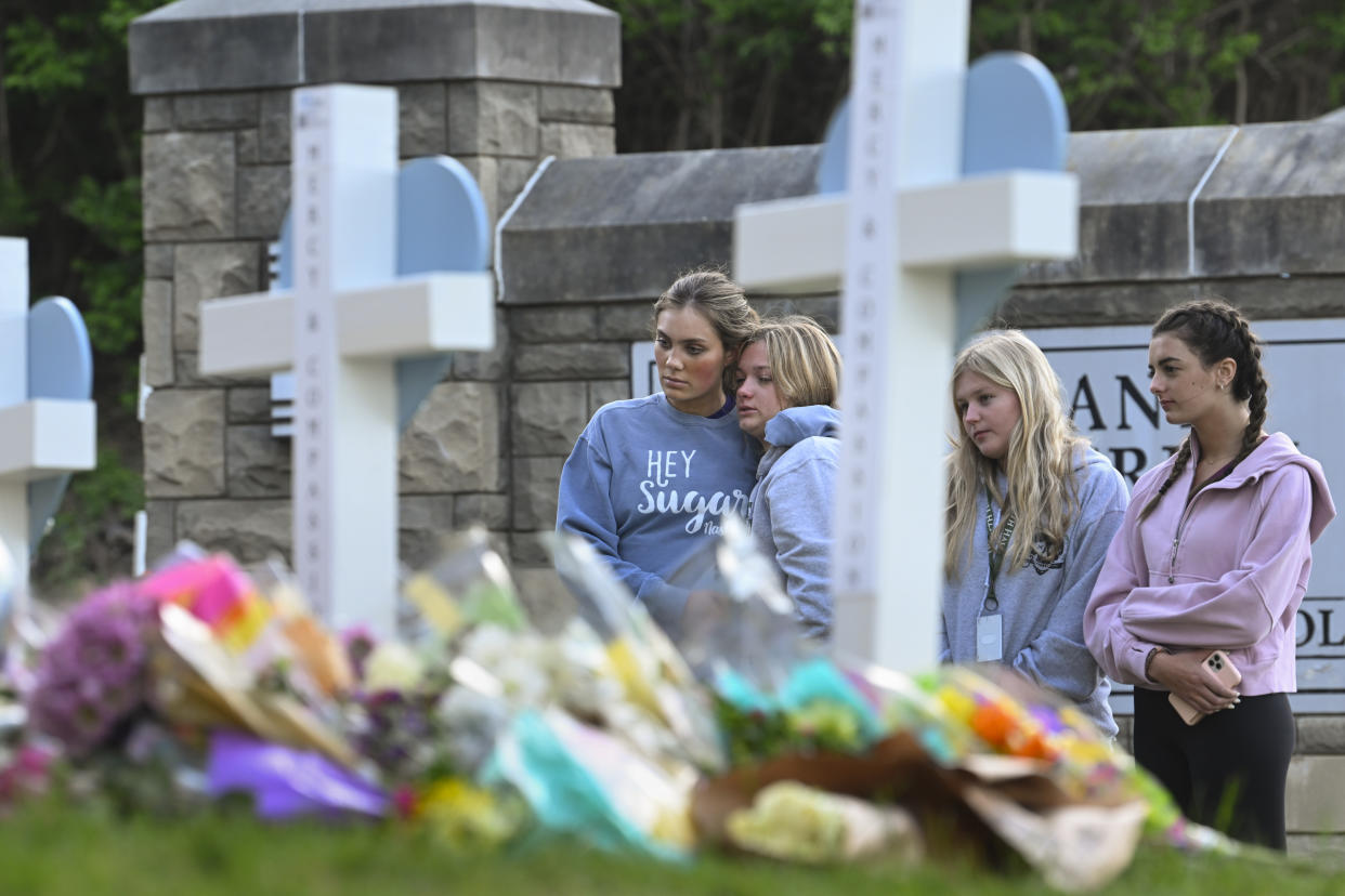 FILE - Students at a nearby school pay respects at a memorial for the people who were killed, at an entry to Covenant School, Tuesday, March 28, 2023, in Nashville, Tenn. More than 100 people have been killed in mass shootings thus far in 2023, an average of one mass killing a week. (AP Photo/John Amis, File)