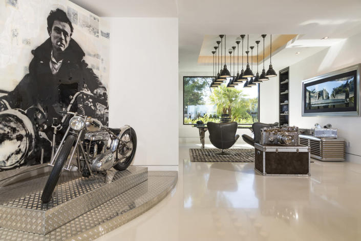 <p>Makowsky commissioned the James Dean artwork on the wall, then had a one-of-a-kind replica of the motorcycle built, too. In the background is an office area. The Leica camera sculpture on the trunk is another art piece, which Makowsky’s team said is worth at least $200,000.</p>