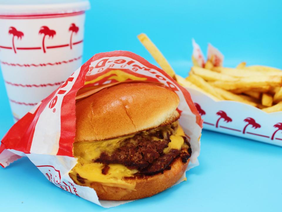 in n out double double, fries, and drink on blue background