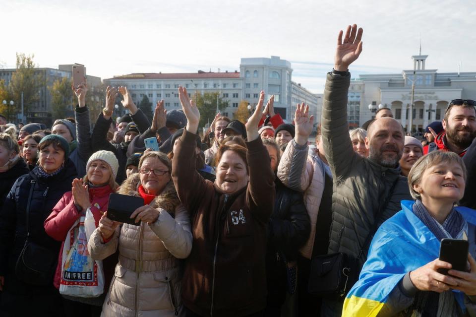 Locals react during the visit of President Zelensky in central Kherson (Reuters)