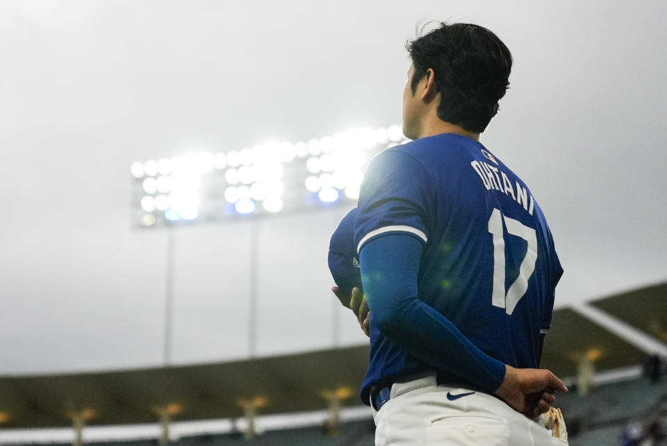 El bateador designado de los Dodgers de Los Ángeles Shohei Ohtani (17) de pie mientras se escucha el himno nacional previo a un juego de pretemporada ante los Angelinos de Los Ángeles, el domingo 24 de marzo de 2024. (AP Foto/Ashley Landis)