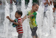 <p>Children cool themselves off in a public water fountain in downtown Seoul, South Korea, Friday, July 22, 2016. A heat wave warning was issued in South Korea as temperatures soared above 35 degrees Celsius (95 degrees Fahrenheit). (AP Photo/Lee Jin-man)</p>