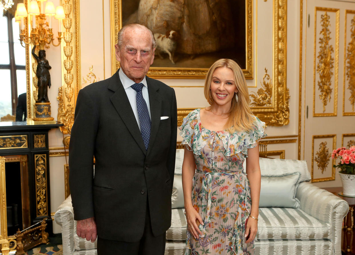 WINDSOR, UNITED KINGDOM - APRIL 04: Prince Philip, Duke of Edinburgh, Patron of the Britain-Australia Society, presents Kylie Minogue with the Britain-Australia Society Award for 2016 during a private audience in the White Drawing Room at Windsor Castle on April 4, 2017 in Windsor, United Kingdom.. The Britain-Australia Award recognises Australian and British individuals who have made a significant contribution to the Australia-UK bilateral relationship. Past recipients include Barry Humphries, and the Rt Hon Lord Hague PC.  (Photo by Steve Parsons - WPA Pool/Getty Images)