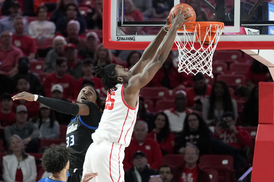 Houston forward Jarace Walker (25) dunks as Tulsa forward Bryant Selebangue (33) defends during the first half of an NCAA college basketball game Wednesday, Feb. 8, 2023, in Houston. (AP Photo/Eric Christian Smith)