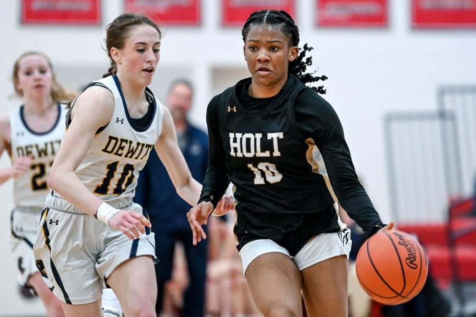 Holt's Rhema Dozier, right, moves the ball as DeWitt's Peyton Anderson defends during the third quarter on Thursday, March 9, 2023, at Coldwater High School.