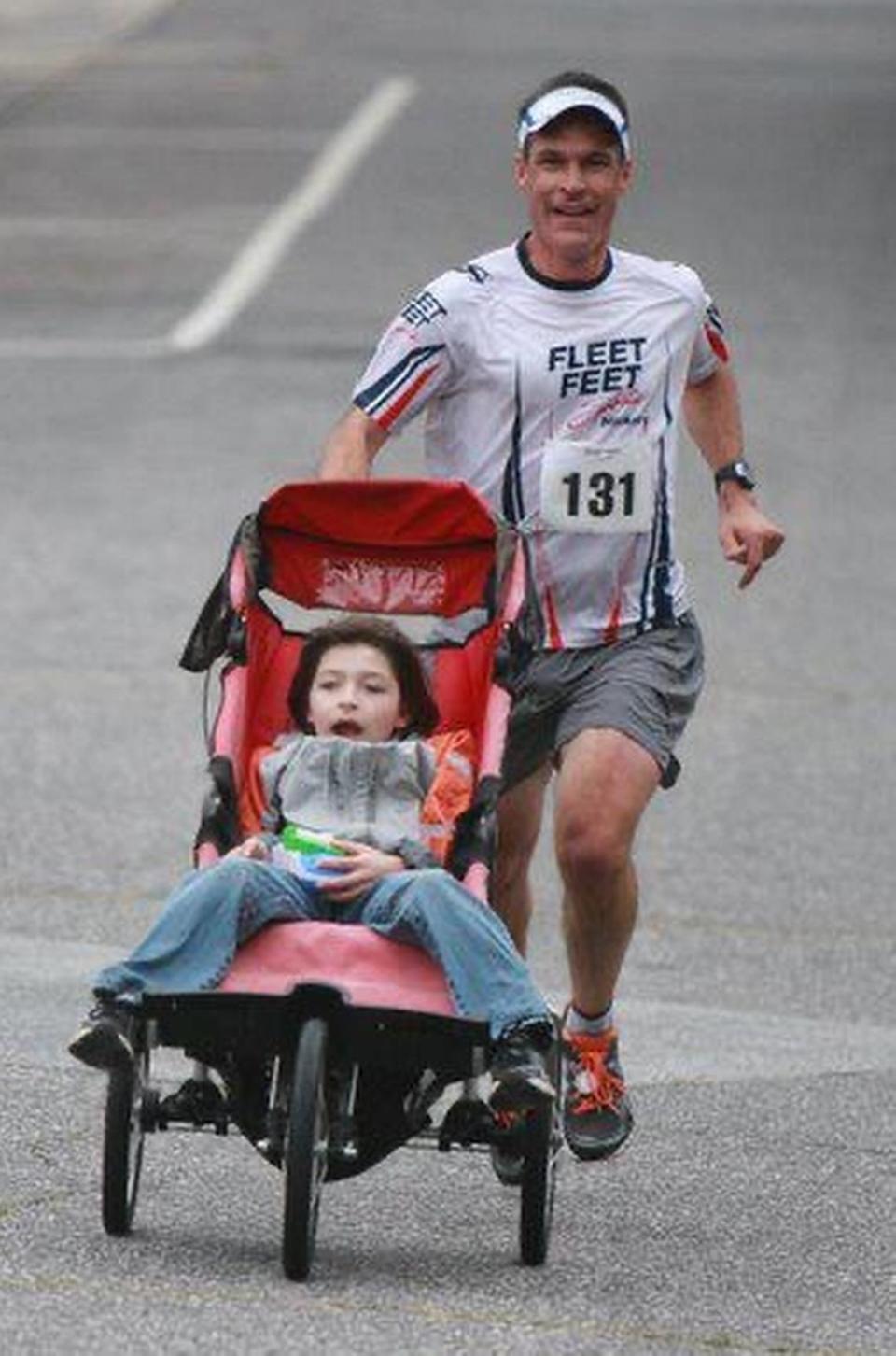 Bill Johncock runs with son Logan in a race in September of 2011.