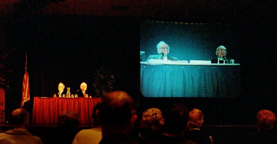 Shareholders of Berkshire Hathaway listen to Warren Buffett, left, and Charlie Munger on closed circut TV at an alternate location with cardboard cutouts at the table shown, as they address questions from sharholders during their annual sharholders meeting Monday May 3, 1999 in Omaha, Neb. (AP Photo/Dave Weaver)